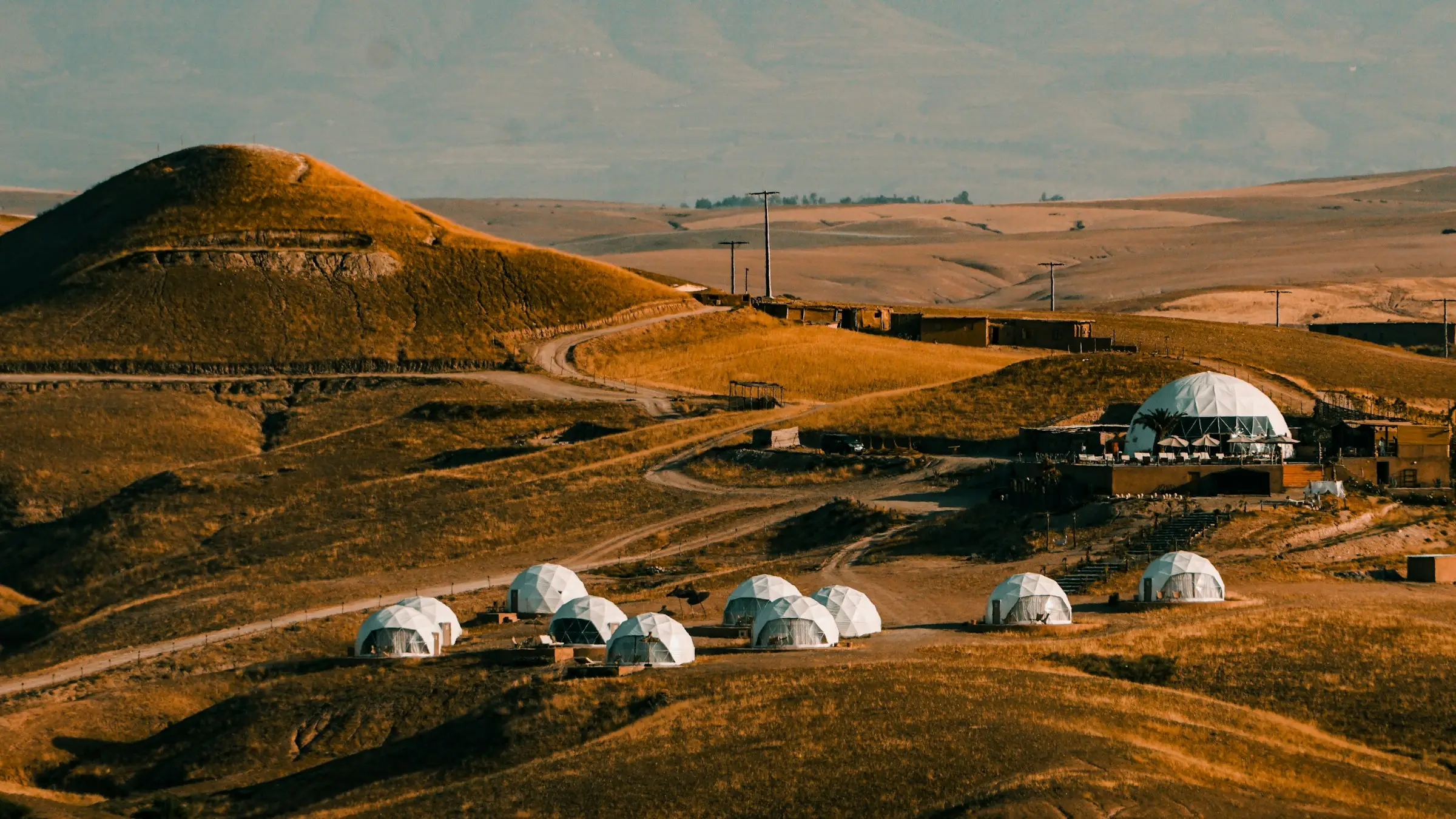 Domos en un paisaje seco de colinas doradas al atardecer