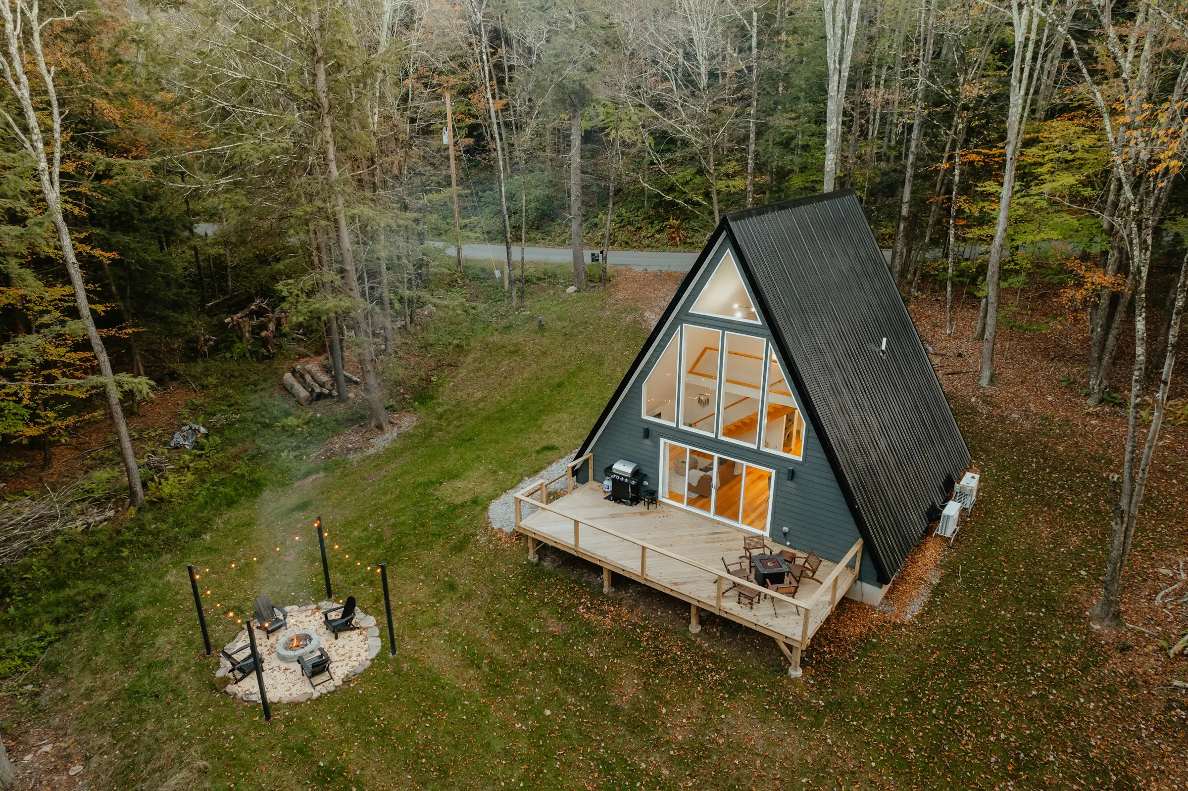 Cabaña A-frame con terraza de madera en un claro del bosque